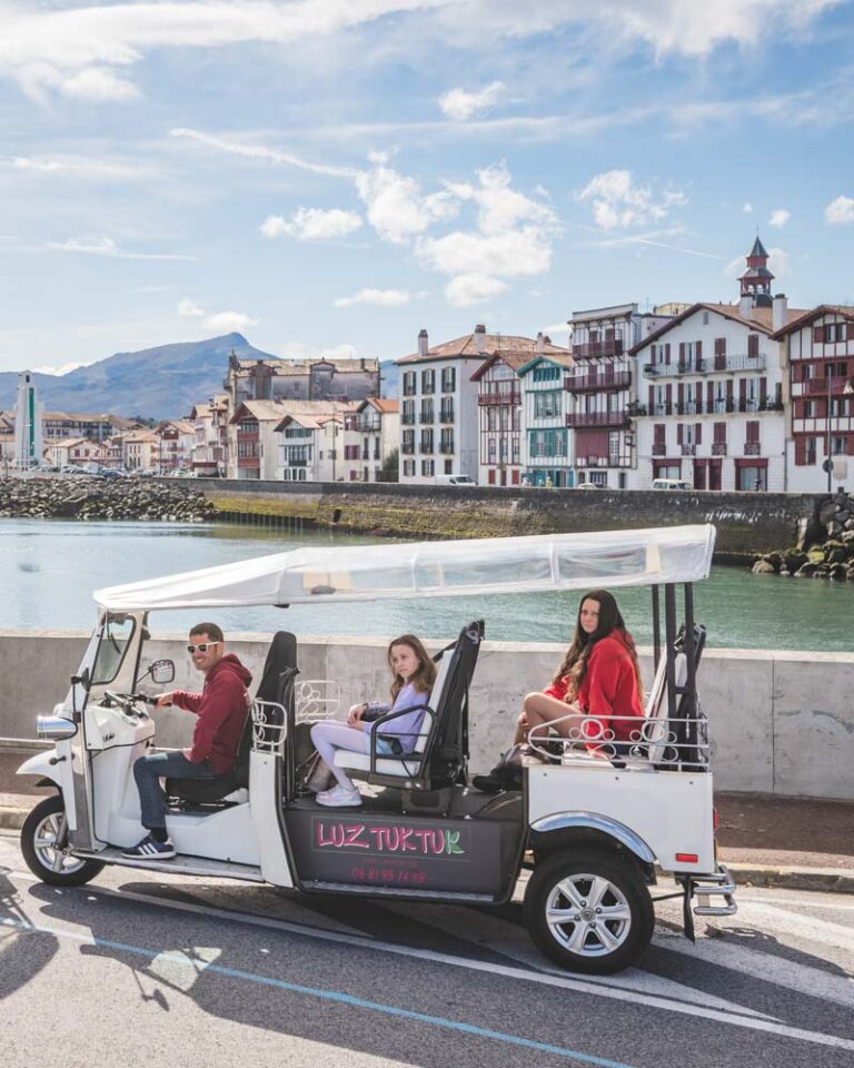 le tuk tuk prend la pause devant la vue sur le port et les façades de Ciboure