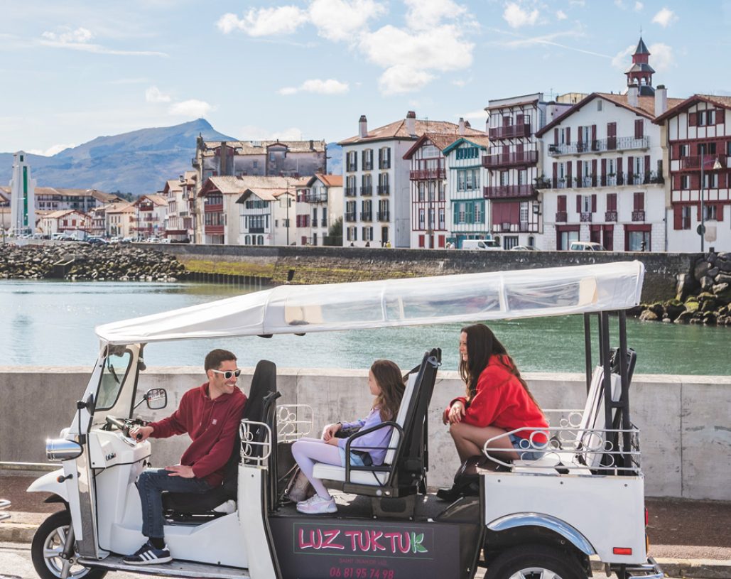 le tuk tuk prend la pause devant la vue sur le port et les façades de Ciboure