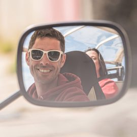 portrait de nicolas le patron de luz tuk tuk dans le rétroviseur du tuk tuk
